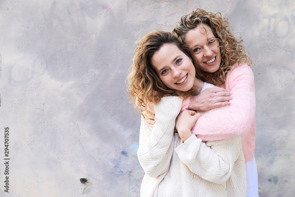 Mother embracing daughter looking at camera. Mother embracing daughter looking at camera.