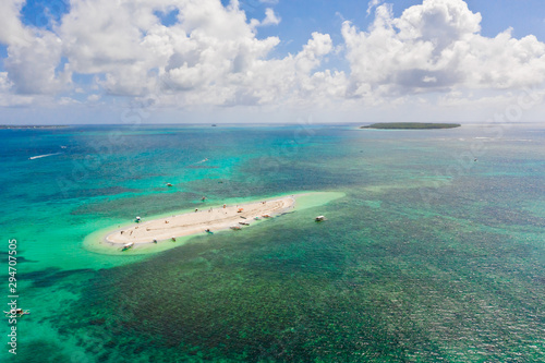 Naked Island  Siargao. The island of white sand on the atoll. Tourists relax on the white island. Seascape with sandy island.