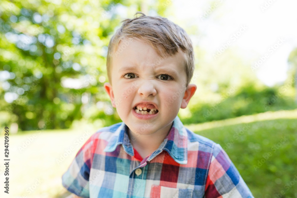 Close-up portrait of school age boy making eye contact and angry face Close-up portrait of school age boy making eye contact and angry face