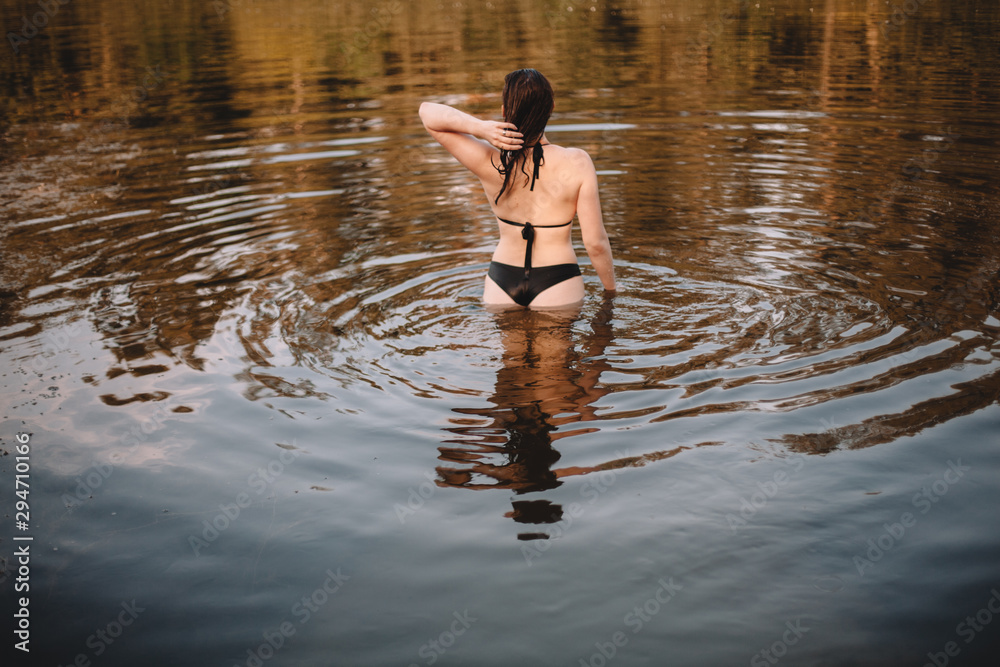 Rear view of woman standing in water Rear view of woman standing in water