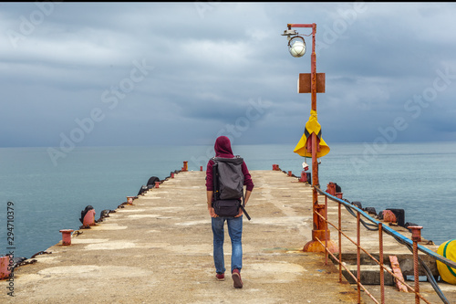 Traveler on the edge of a cliff in the sea photo