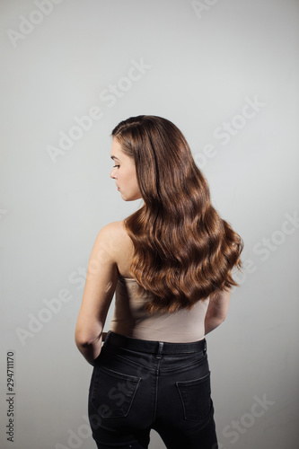 Closeup of female hands of hairdresser or coiffeur makes hairstyle. Hair