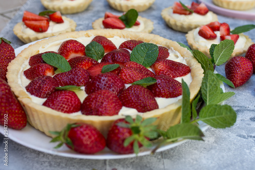 Tart with strawberries and whipped cream decorated with mint leaves
