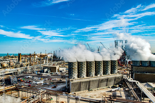 Cooling towers inside a refinery emit steam photo