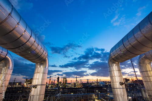 Sunset as viewed through pipe in refinery