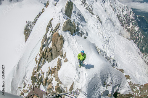 Senior alpinist stands on the final feet of the famous Cosmiques ridge photo