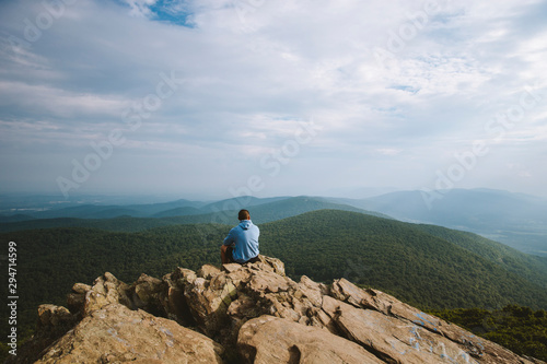 A young adult overlooks a wide mountain range in Virginia