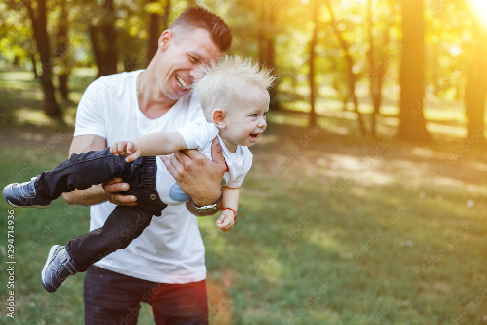 Fototapeta premium Young father plays with the child in the park.