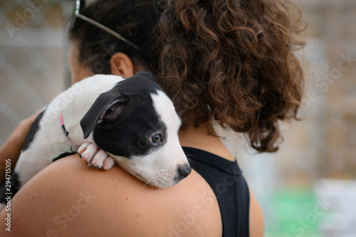 Woman holding a young puppy over her shoulder