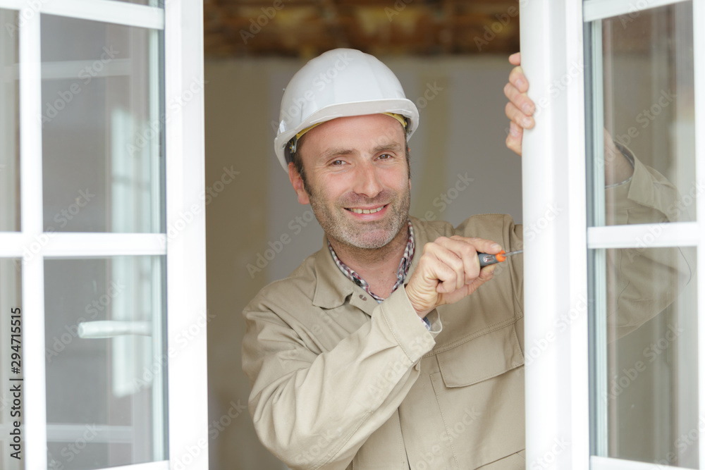 portrait of middle-aged glazier working on window portrait of middle-aged glazier working on window