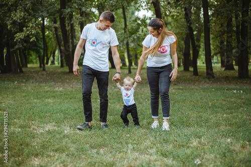 Happy family in a park on the green grass.