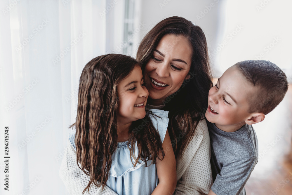 Mother, daughter, and son laughing at each other in studio Mother, daughter, and son laughing at each other in studio