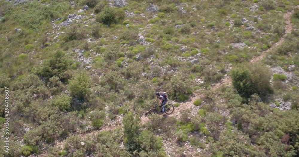 Aerial view of mountain biker on arduous off road path. Aerial view of mountain biker on arduous off road path.
