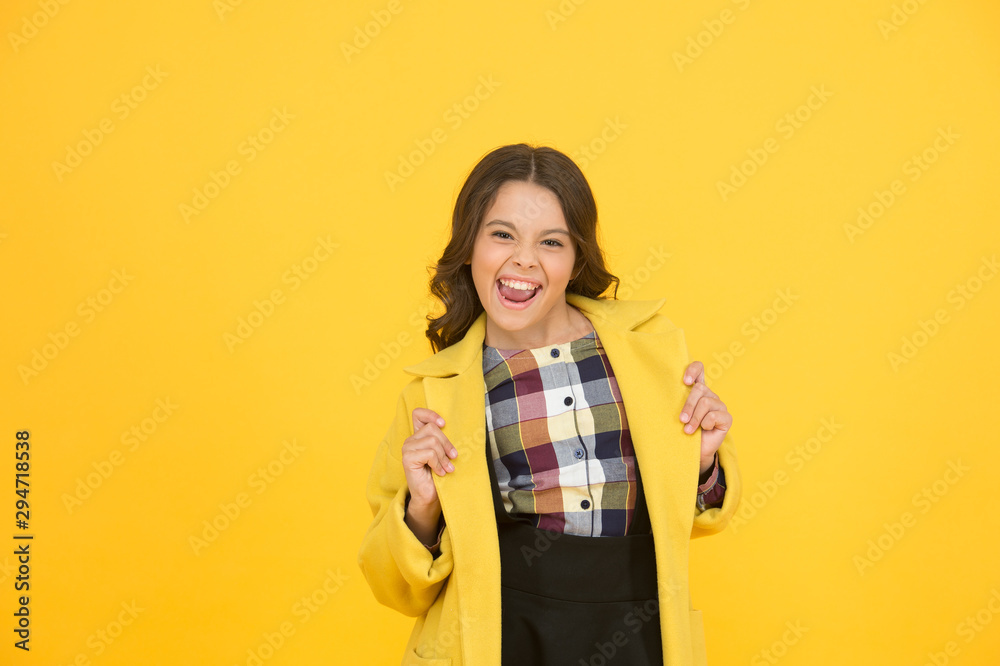 Yellow mood. Fancy child smiling face on yellow background. Yellow color. Girl fashionable cute model wear yellow wool coat. Personal styling and bespoke tailoring. Feeling cozy and comfortable Yellow mood. Fancy child smiling face on yellow background. Yellow color. Girl fashionable cute model wear yellow wool coat. Personal styling and bespoke tailoring. Feeling cozy and comfortable