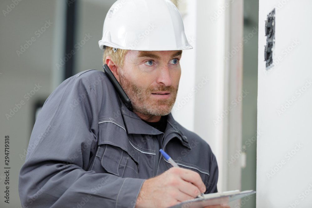 engineer with clipboardn helmet using smartphone engineer with clipboardn helmet using smartphone