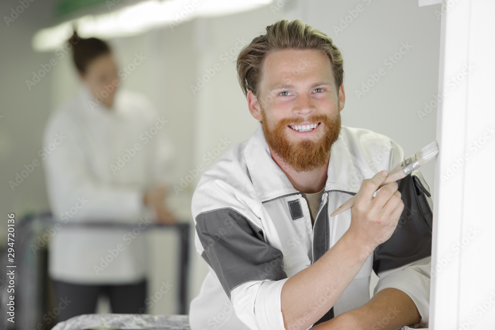 Obraz premium male painter in uniform with brush indoors