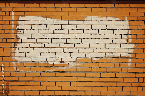 The texture of a brick wall with a spot of paint cream shade