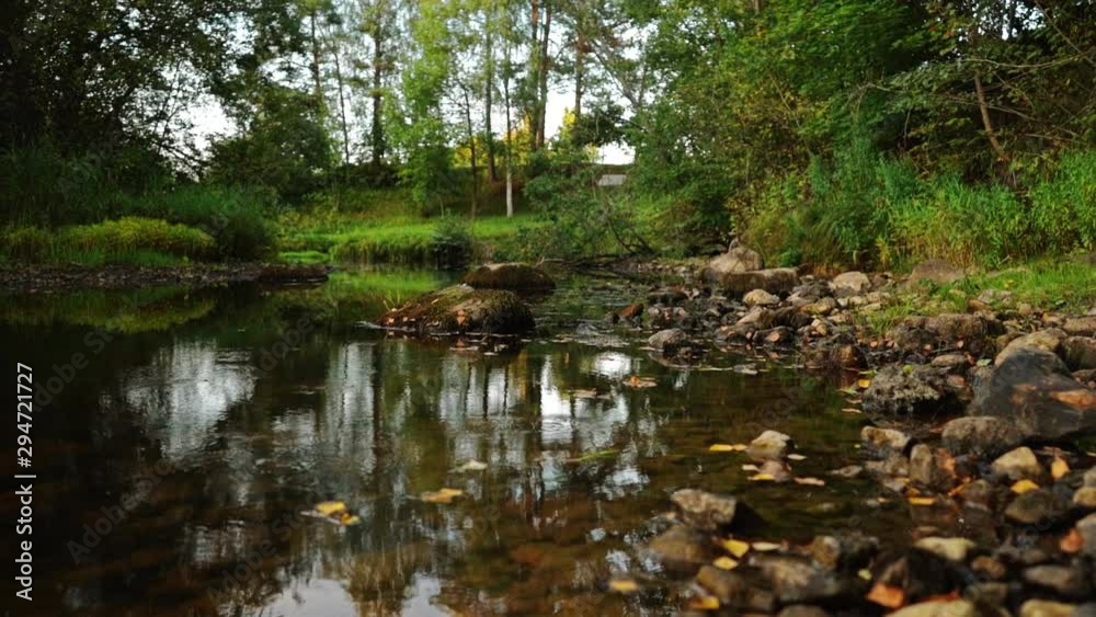 Steadicam shot of river flowing through summer forest at sunset. Nature landscape. Slow motion footage. Steadicam shot of river flowing through summer forest at sunset. Nature landscape. Slow motion footage.