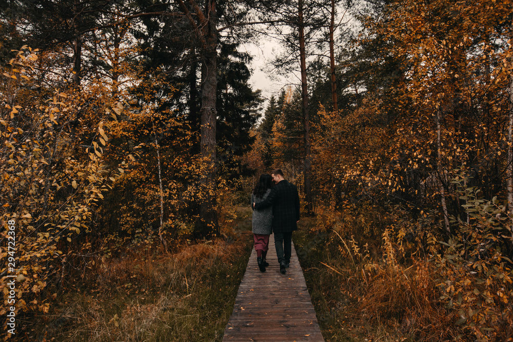 A man and a woman on a date in the autumn forest.