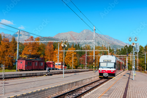 Arrival of the red train on Strbske pleso station in autumn Slovak Tatras