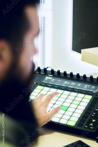 Bearded man working at mixing panel in his sound recording studio photo