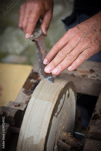 Sharpening knife on old grindstone wheel