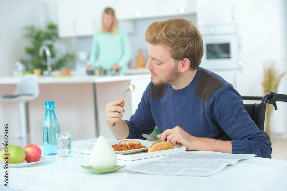 disabled man in wheelchair eating at home