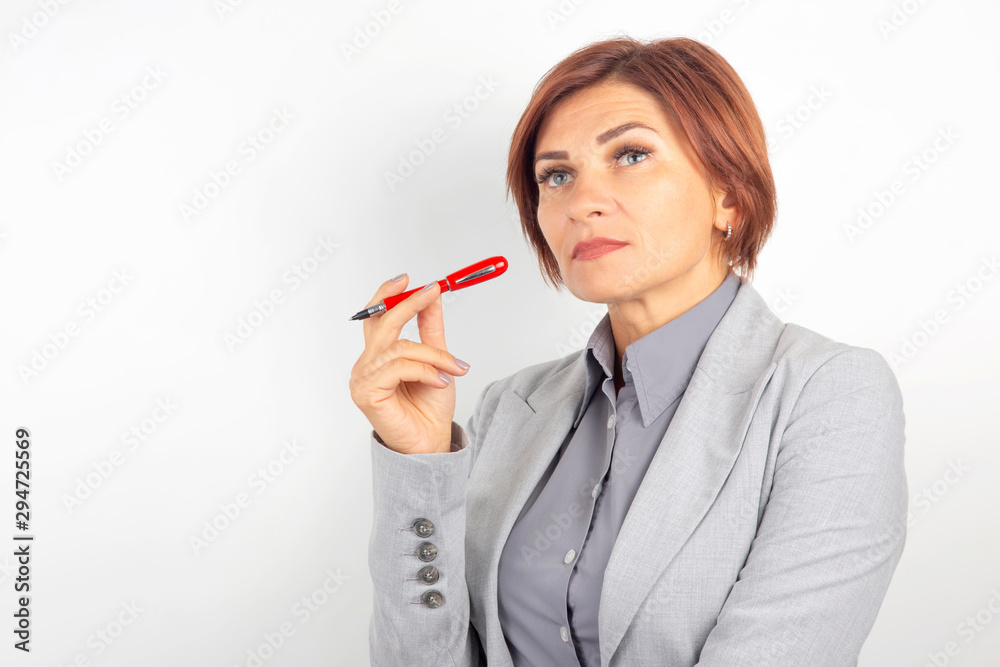 Beautiful young business girl with a red pen in hand on a white background Beautiful young business girl with a red pen in hand on a white background