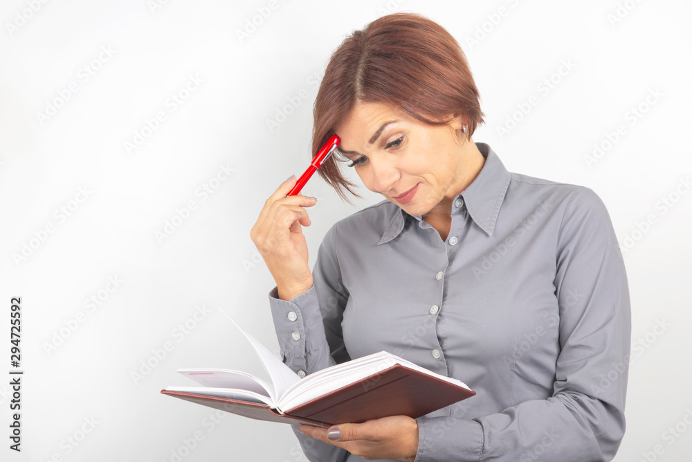 Beautiful young business girl with a red pen and notebook in hands on a white background Beautiful young business girl with a red pen and notebook in hands on a white background