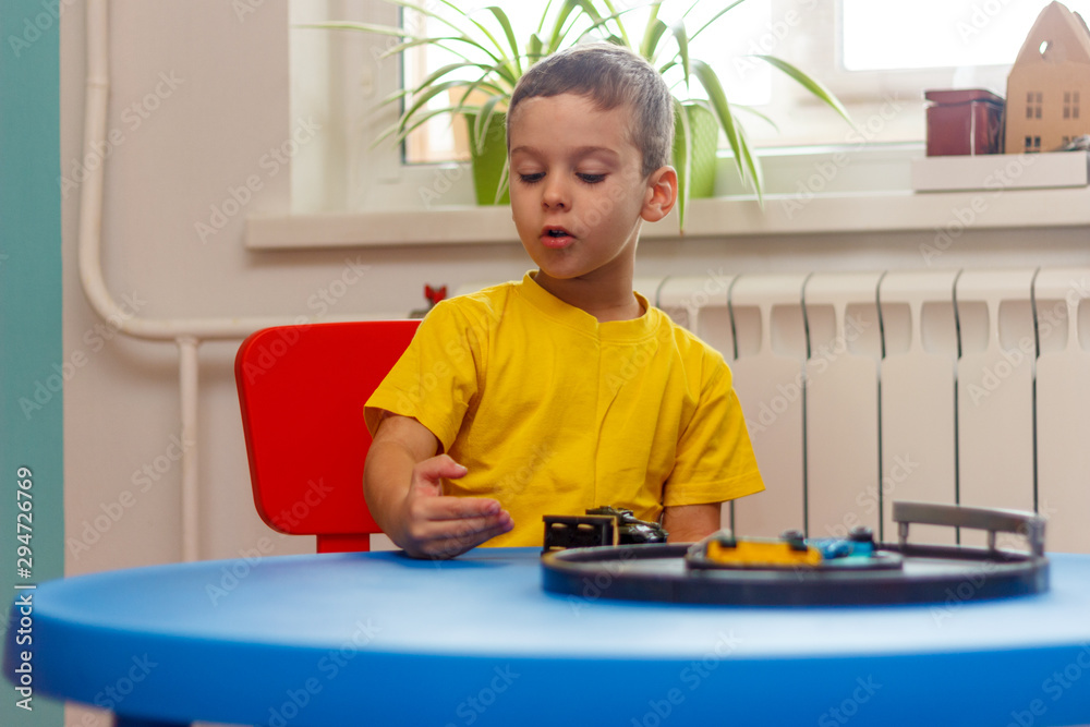 Little boy in yellow t-shirt playing with cars and toys at home, indoor Little boy in yellow t-shirt playing with cars and toys at home, indoor