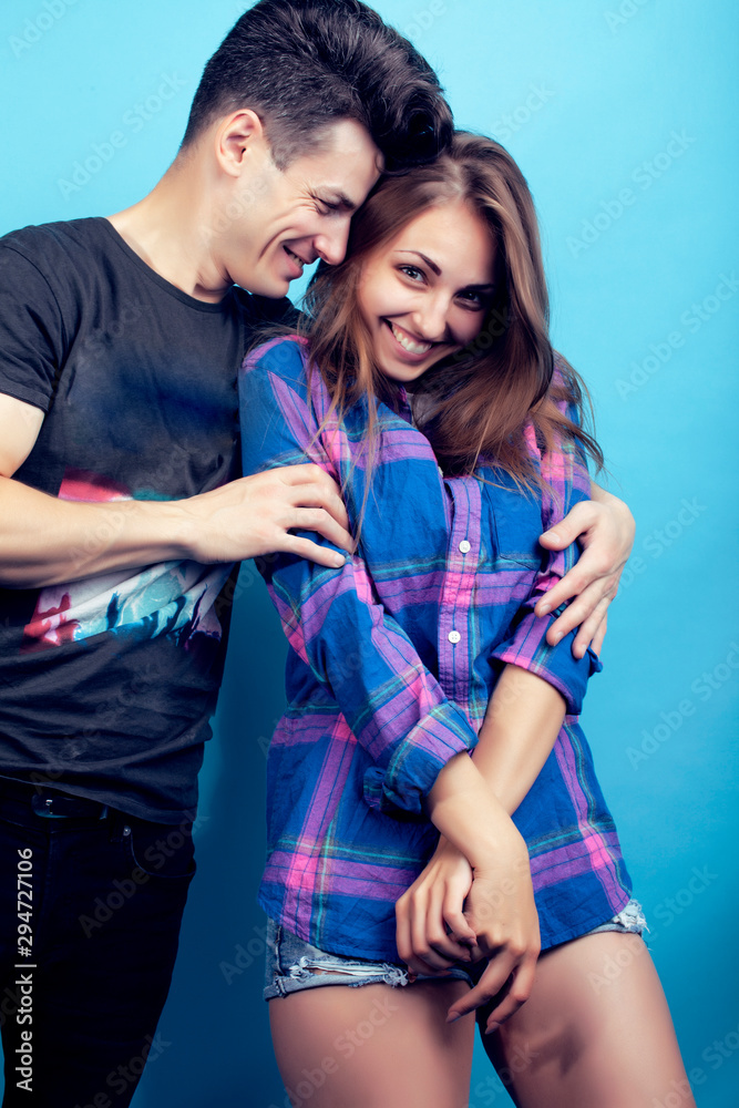 Naklejka premium happy couple together posing cheerful on blue background , guy and girl students together friends