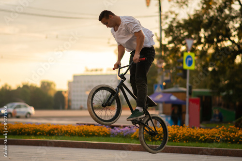 The guy performs a stunt on BMX, jumping high up.