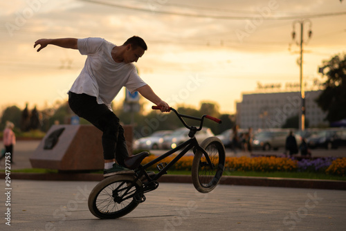 Fototapeta Naklejka Na Ścianę i Meble -  The guy performs a stunt on BMX, standing on the rear wheel.