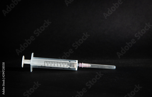 Syringe on dark background. The concept of treatment, health problems. Problems with addiction, treatment from problems with drug abuse.