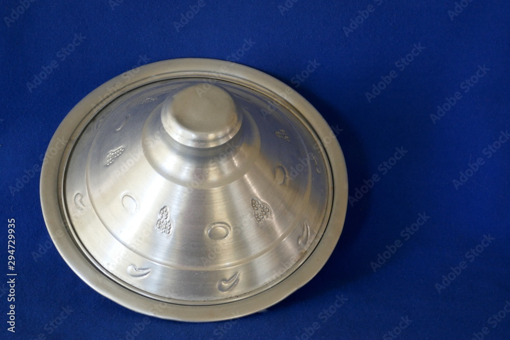 Tajine, typical Moroccan cookware and kitchen utensil. Close up, isolated on blue background Tajine, typical Moroccan cookware and kitchen utensil. Close up, isolated on blue background
