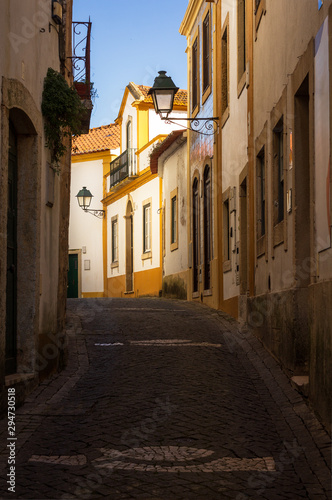 Highlighted white and yellow house on a street in the historic center of Const    ncia  in Portugal.