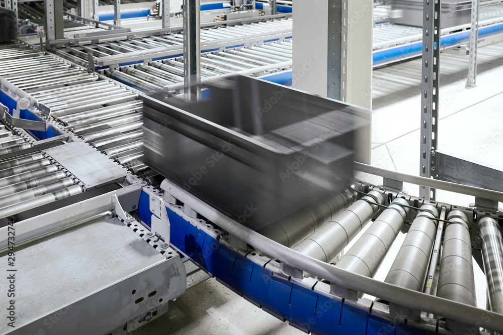 Transportation line conveyor roller with container in motion, selective focus. Transportation line conveyor roller with container in motion, selective focus.