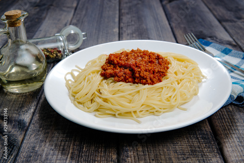 Spaghetti on a dark wooden table. Food and meal preparation concept. Pasta with tomato sauce and spices. Food spaghetti bolognese.