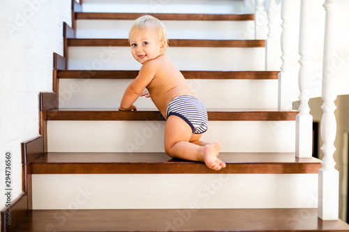 10 months adorable blonde baby development , climbing up stairs at home
