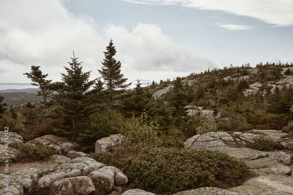 Hiking along granite bedrock on the summit of Cadillac Mountain in Acadia National Park on Mount Desert Island, Maine. Hiking along granite bedrock on the summit of Cadillac Mountain in Acadia National Park on Mount Desert Island, Maine.