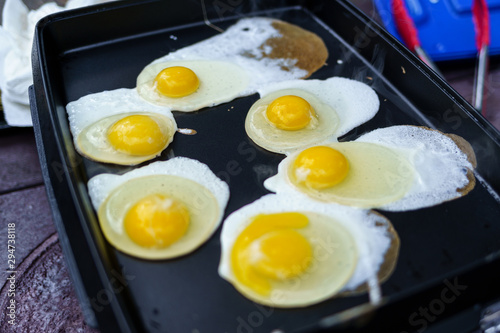 Six eggs cooking on camping griddle