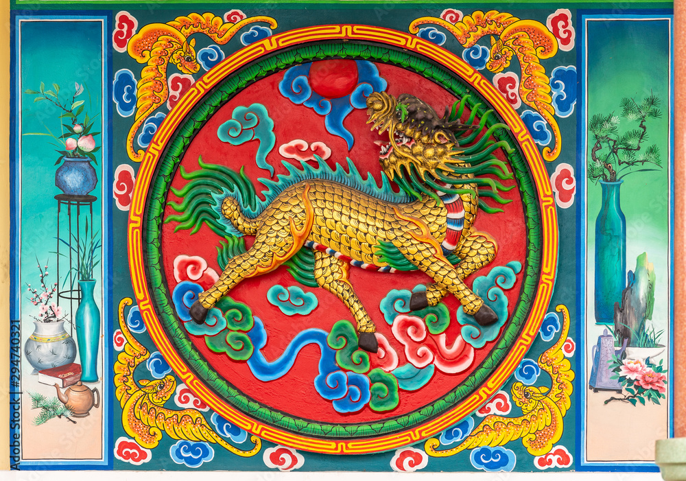 Fototapeta premium Bang Phra, Thailand - March 16, 2019: Chao Pho Khao Chalak Chinese Cemetery. Reunion hall and shrine for mourning families. Outer wall painting of monster liion in vivid colors.