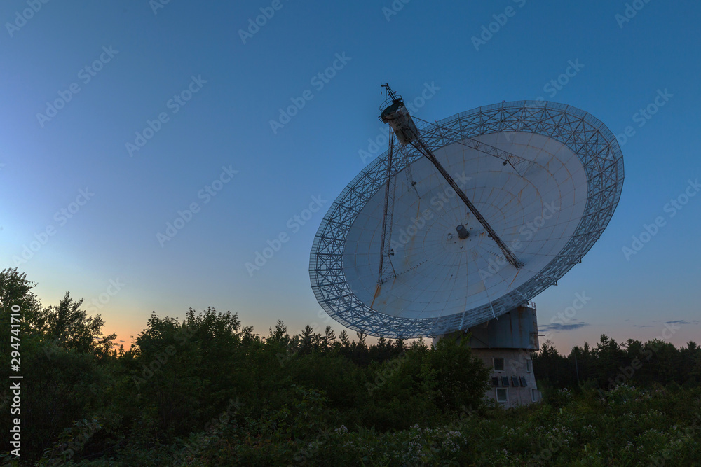 A large radio telescope at dusk 