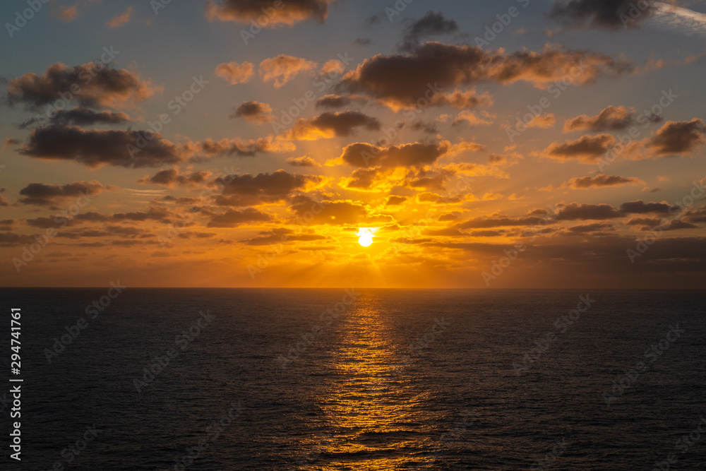 God rays in a orange sunset at sea