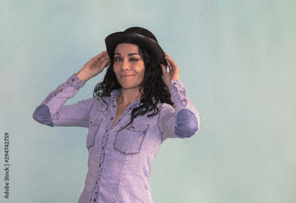 Brunette woman with black hat winking an eye to the camera Brunette woman with black hat winking an eye to the camera