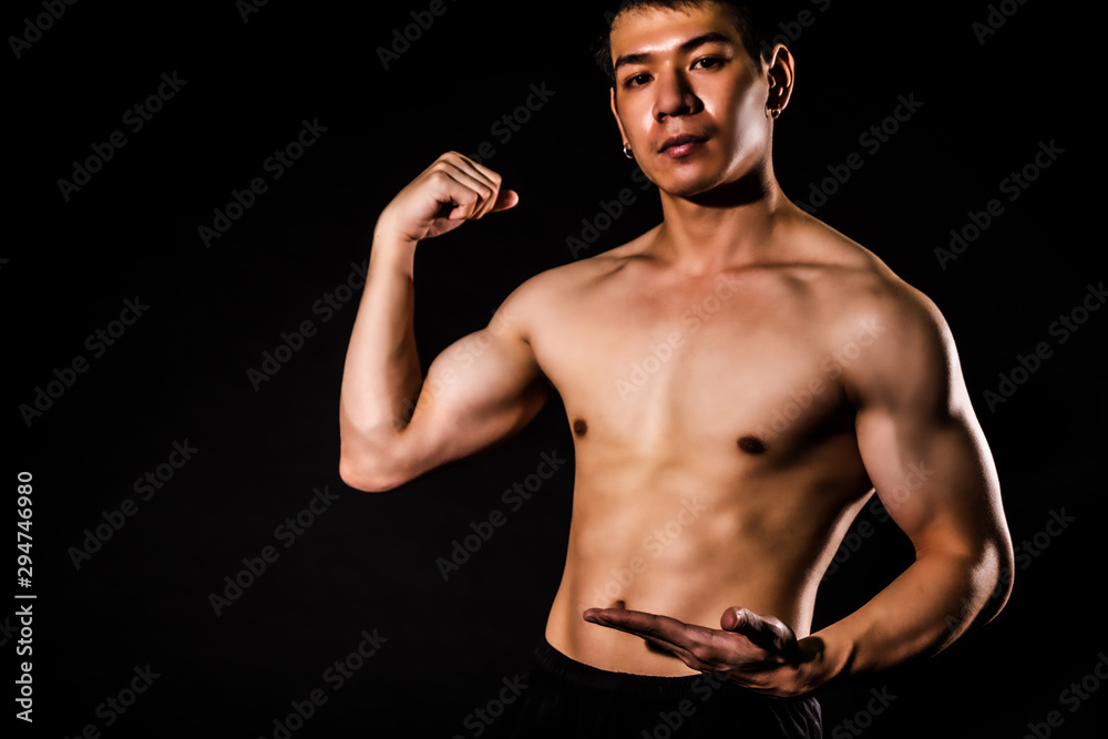 Obraz premium sport man standing showing muscle bodybuilding on black backgrounds, fitness concept, sport concept