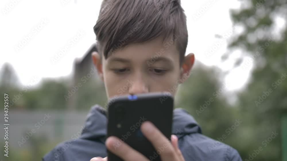 boy uses a phone outdoors close up, moving camera boy uses a phone outdoors close up, moving camera