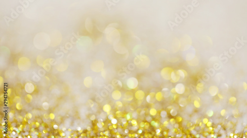 Lights on gold with star bokeh background.Gold celebration background for anniversary, New Year Eve, Christmas, falling coins, wedding or birthday