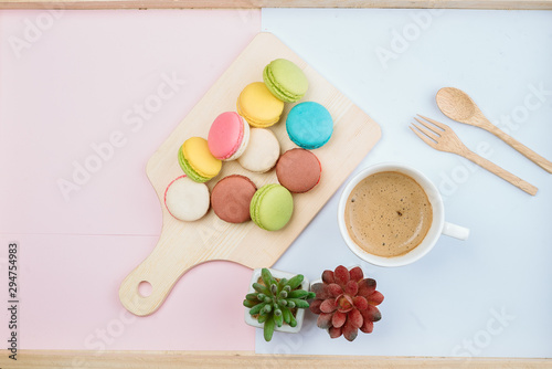 Delicious and colorful macarons placed on a wooden tree decorated with sweet coffee.