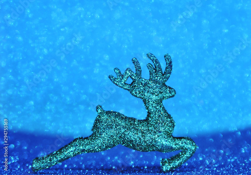 Christmas deers on blue sparkling glitter background. Festive concept. © Alona